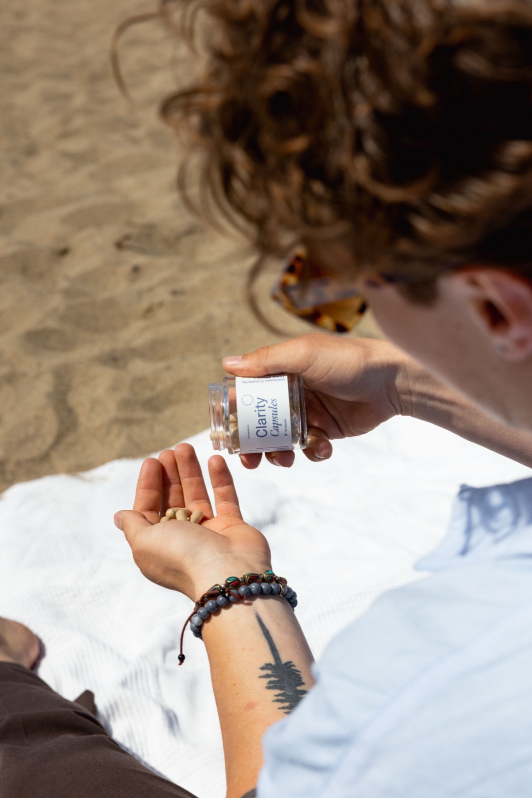 0A0A6794 web - Blog Person sitting calmly outdoors holding Microgenix Clarity capsules, looking relaxed and unhurried