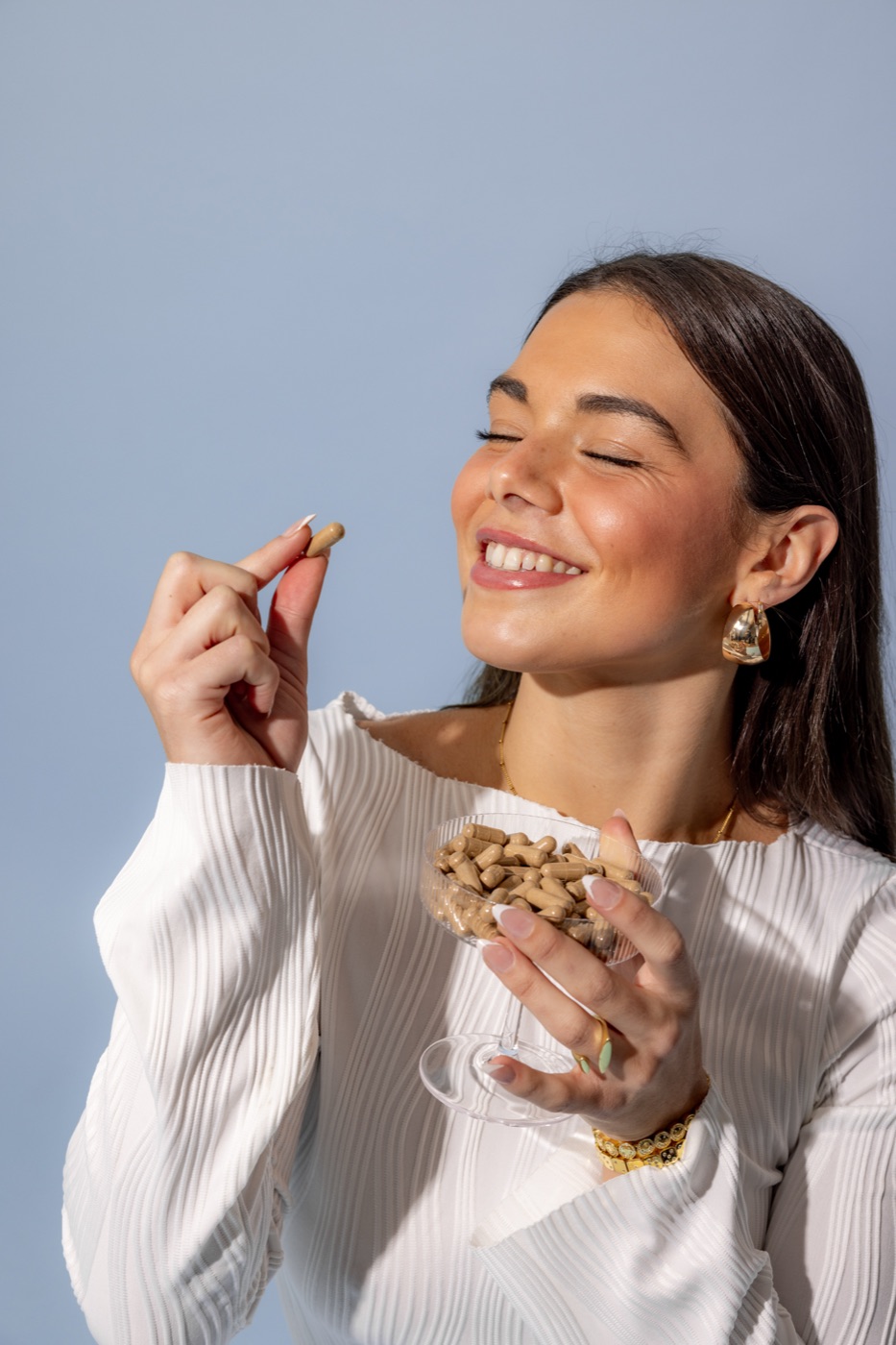 mgx present not numb - Blog Young woman smiling with eyes closed holding Microgenix capsules, present and clear-headed