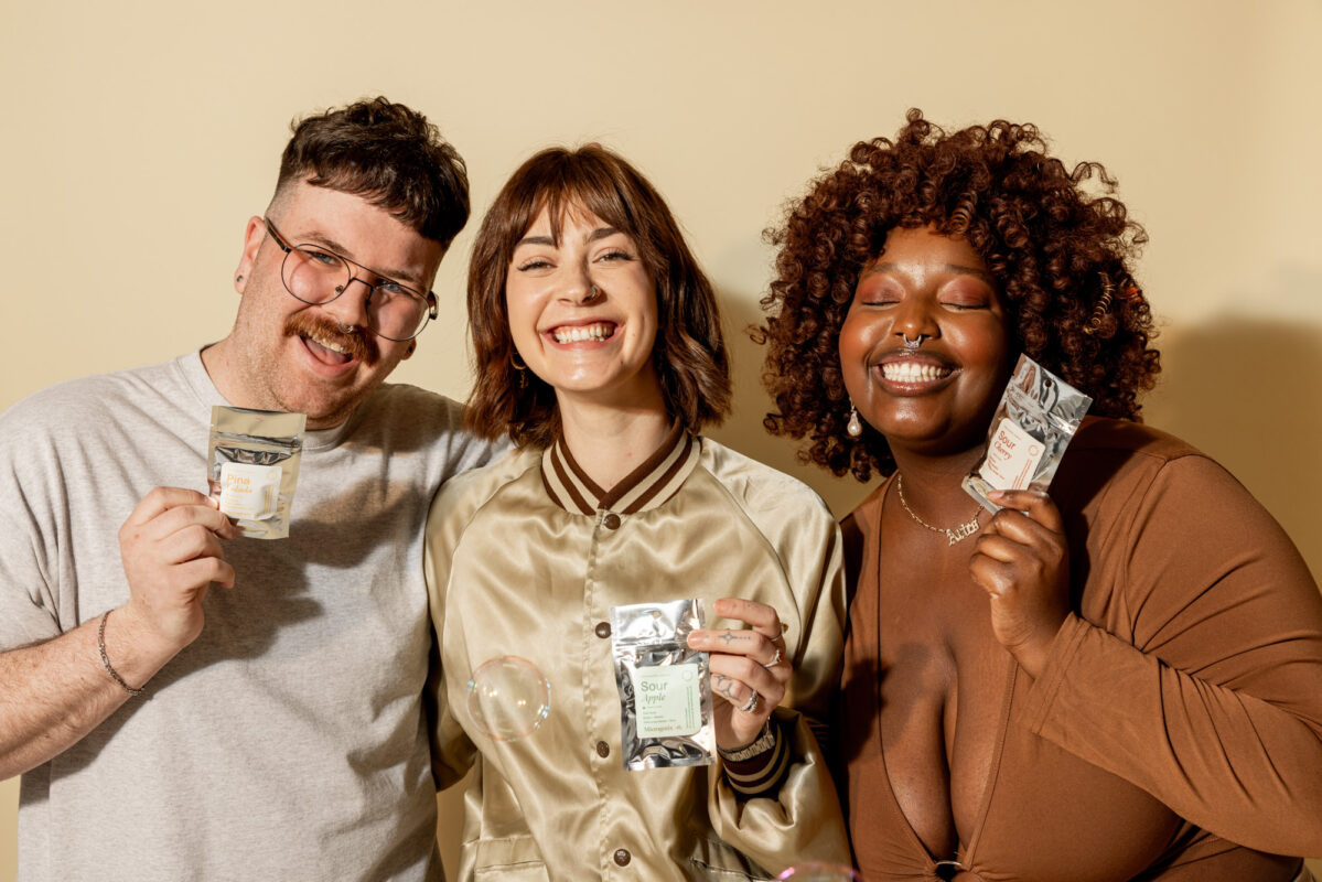 microgenix microdosing benefits hero - Blog Three friends laughing together holding Microgenix gummies