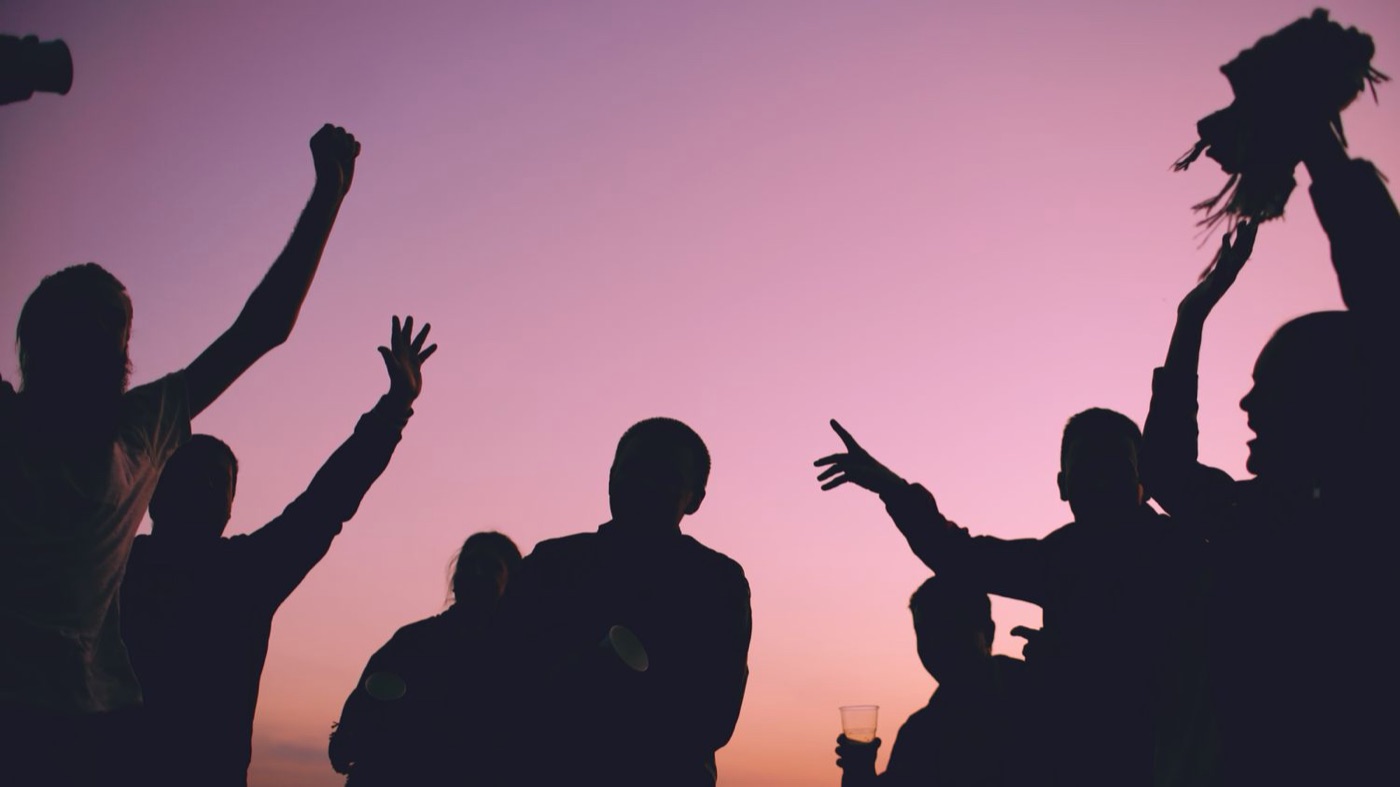 crowd silhouette sunset - Blog Silhouettes of festival-goers dancing with raised arms against a pink sunset sky