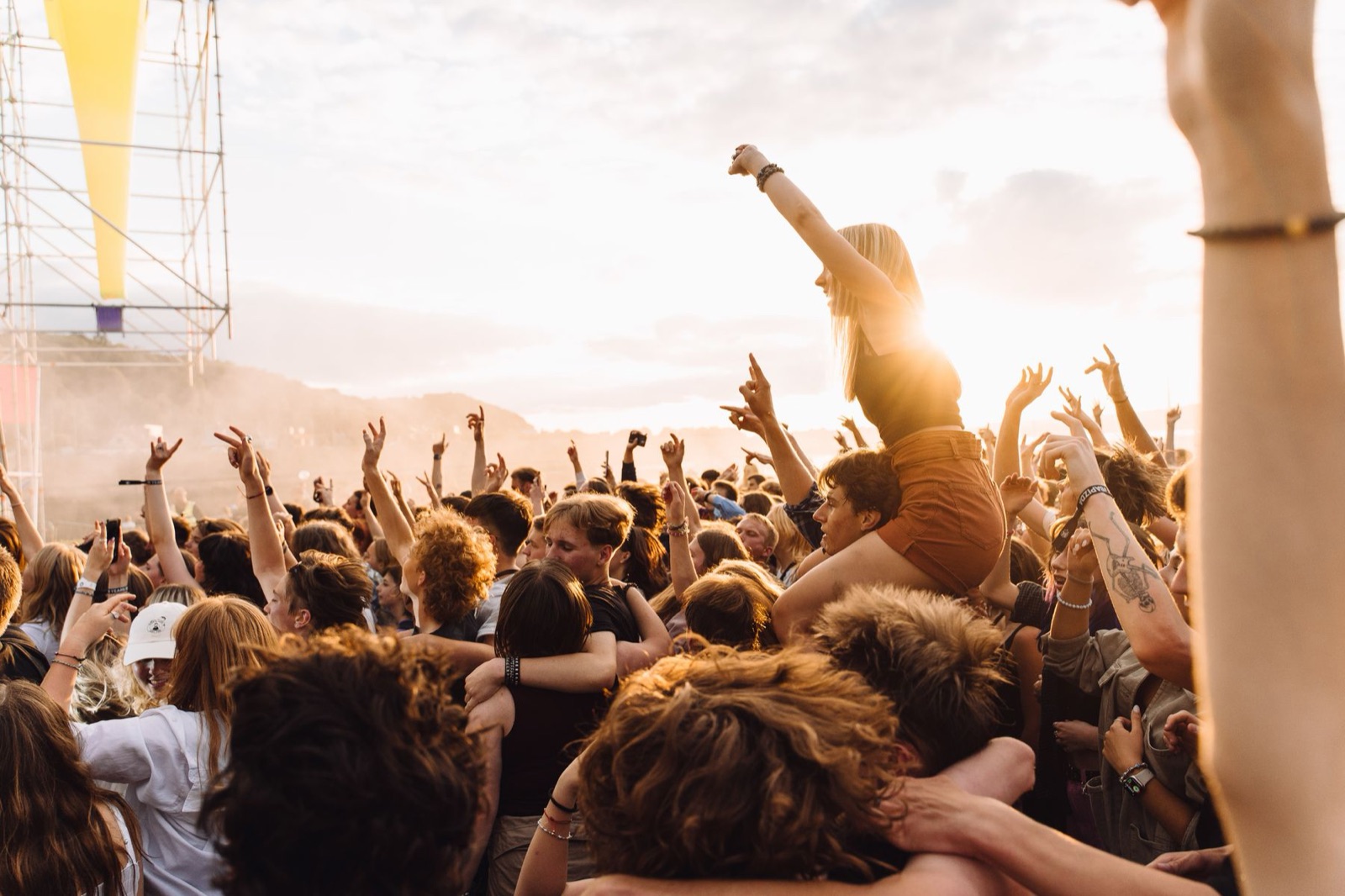 hero festival crowd - Blog Crowd with arms raised at an outdoor music festival in golden evening light