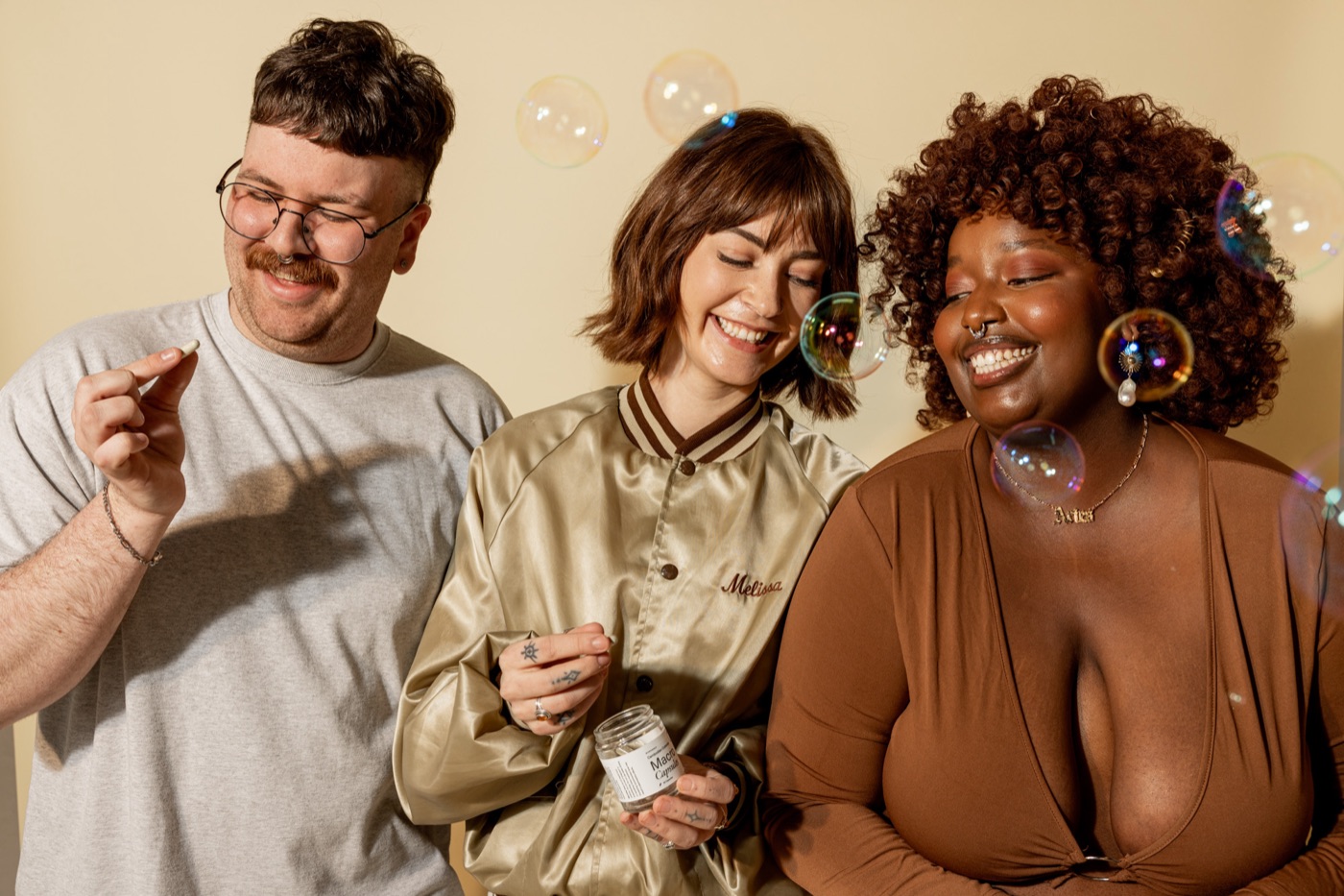 mgx friends bubbles - Blog Three friends laughing together while holding Microgenix capsule jars