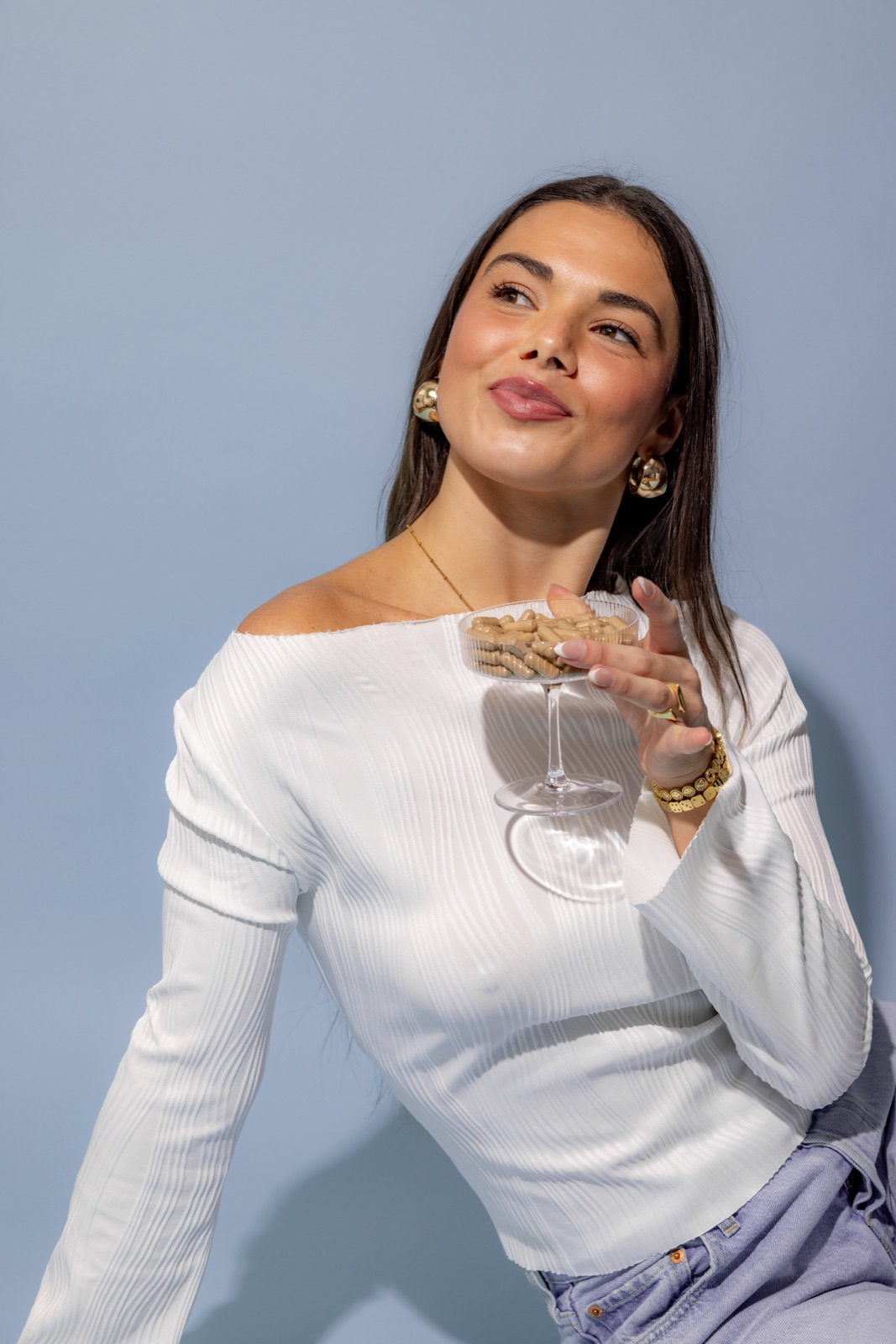 microdosing cost hero - Blog Smiling woman holding a coupe glass filled with Microgenix microdose capsules