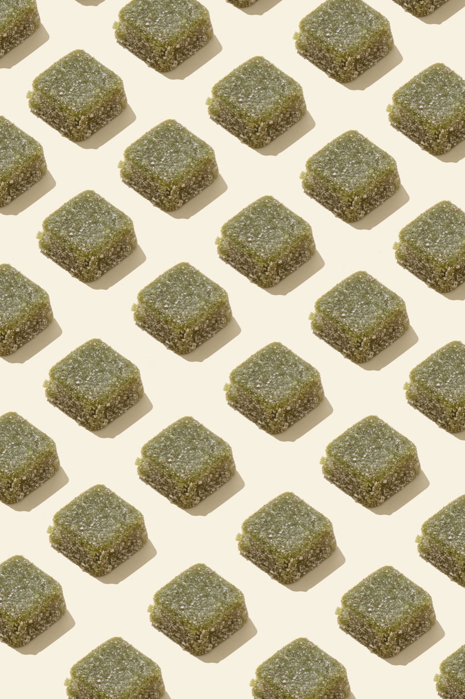 Grid of sugar-coated Microgenix mushroom gummies arranged on a cream background