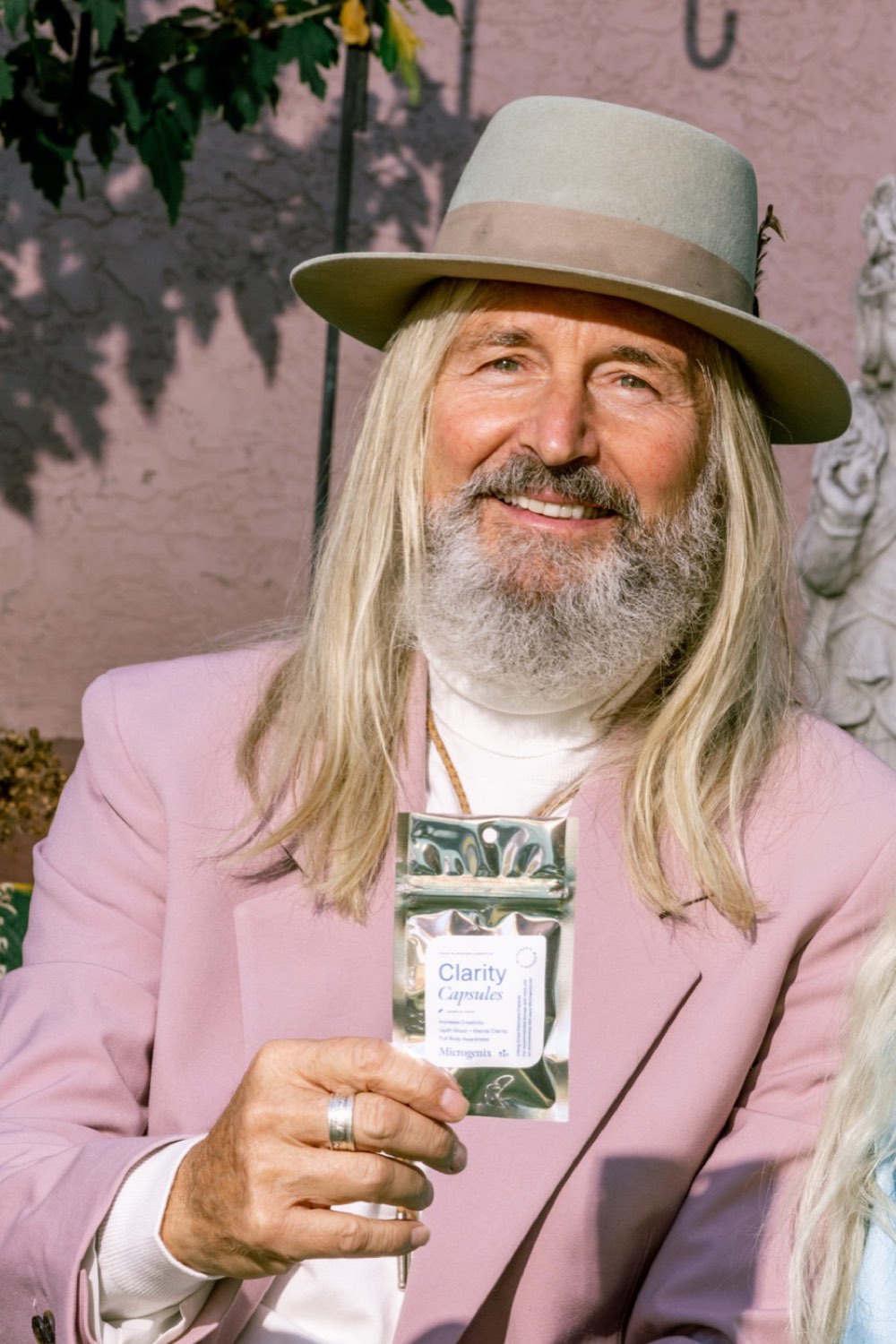 aging man - Blog An older man in a hat holding a jar of Microgenix capsules