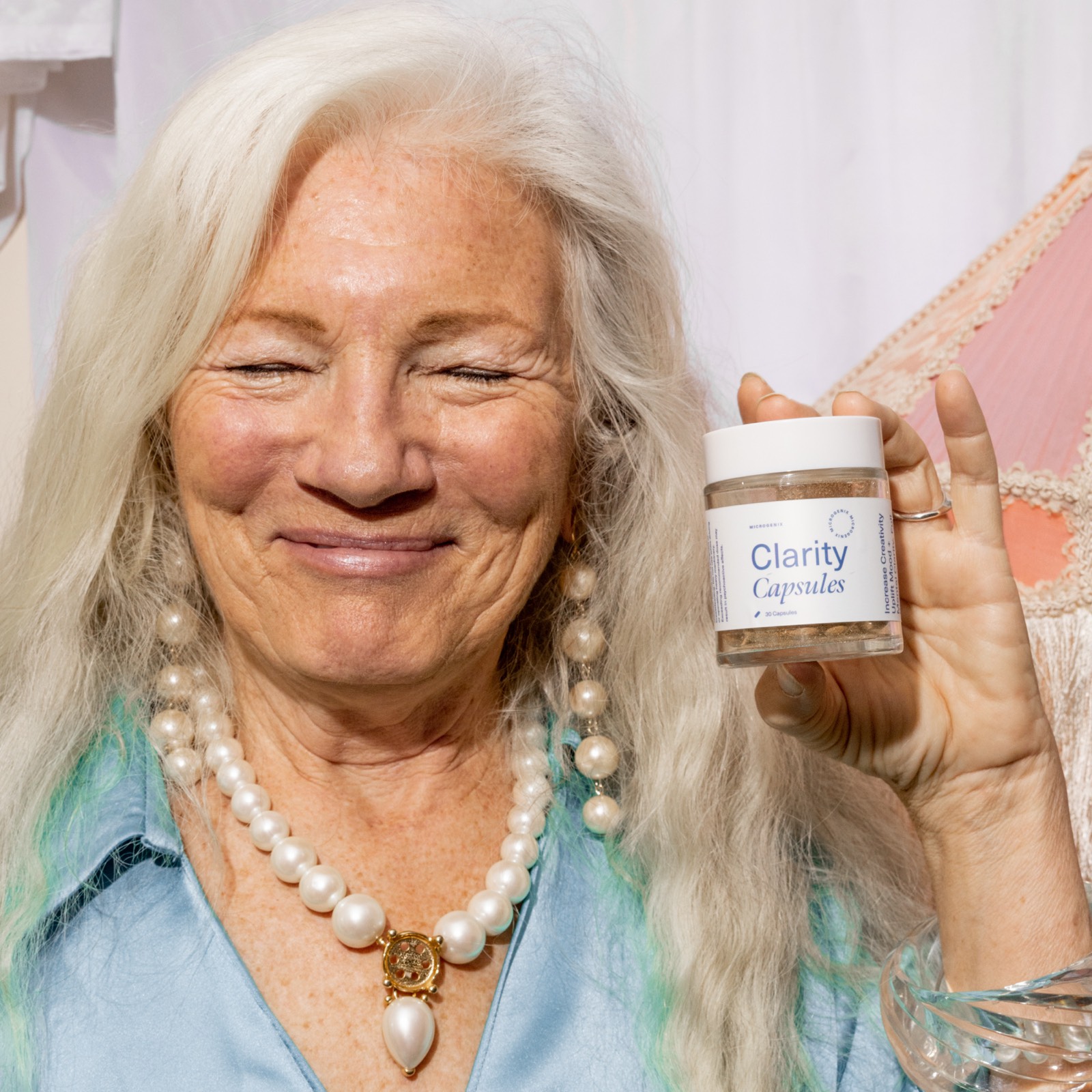 fifty plus hero joy - Blog A silver haired woman laughing with her eyes closed while holding a jar of Microgenix Clarity capsules