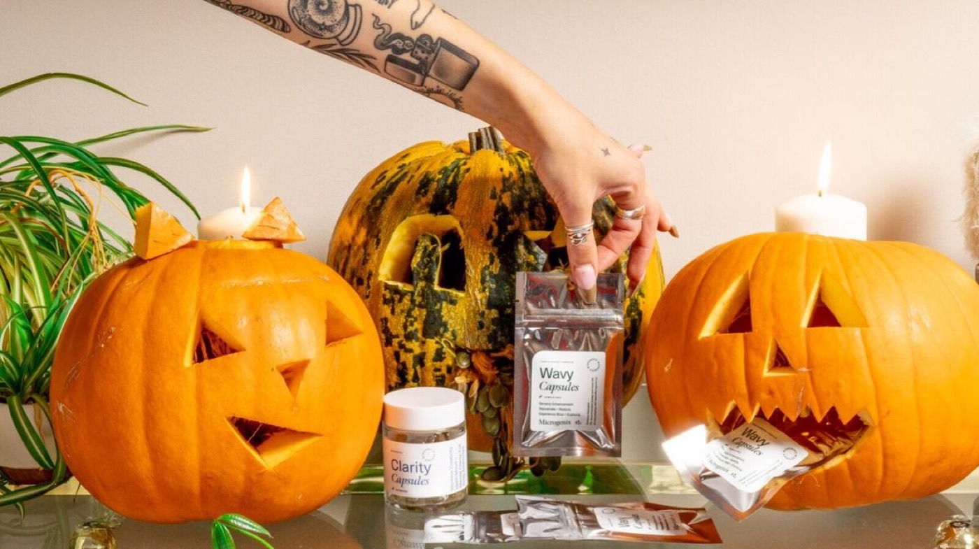 hw26 blog mgx hw lanterns wavy - Blog Two glowing jack o lanterns on a table beside a jar of Microgenix Wavy capsules